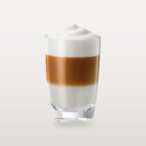 A caffè latte in a tall glass, coffee and steamed milk blended under a soft cap of foam