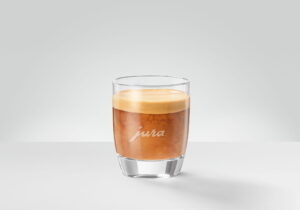 A cortado in a small glass, espresso and warm milk in equal parts with a thin pale band on top