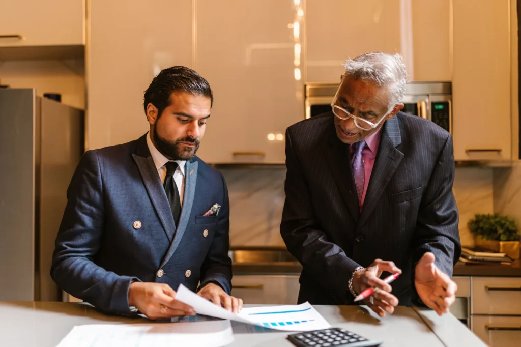 Two advisers reviewing a financial chart across the counter of a bright office kitchen